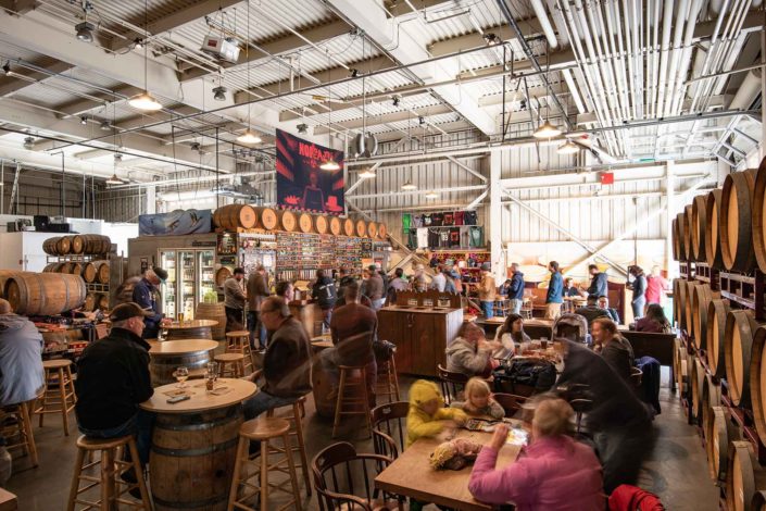 People enjoying food and beer at tables in side Drake's Barrel House